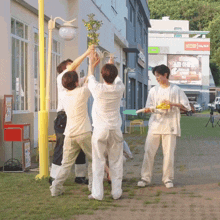 a group of young men are standing in front of a building with a sign that says ' dms ' on it