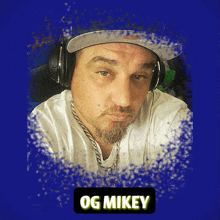 a man wearing headphones and a hat has og mikey written on the bottom