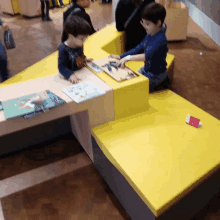 a boy sits at a table with a book that says ' i love you ' on the cover