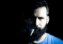 a man with a beard is smoking a cigarette with smoke coming out of his mouth