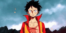 monkey d luffy from one piece is standing in front of a mountain in a red and yellow jacket .