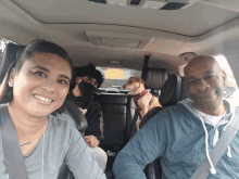 a family in a car with a dog and a man wearing a black mask