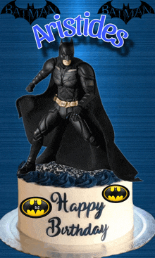 a birthday cake with a batman figurine on top of it