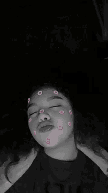 a girl with pink circles on her face is making a funny face .