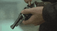a close up of a person holding a gun with an o on the grip