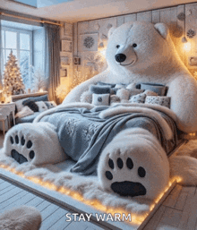 a bedroom with a giant teddy bear bed and the words stay warm below it