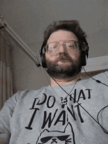 a man wearing glasses and headphones is wearing a shirt that says do what i want