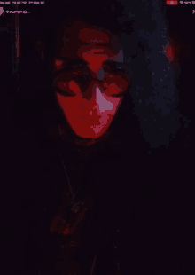 a close up of a person 's face with a red light behind them