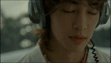 a close up of a person wearing headphones with the letter s on the left side