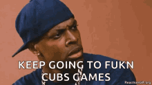 a man wearing a blue hat says keep going to fukn cubs games