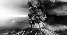 a black and white photo of a volcano erupting with smoke coming out of it