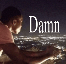 a man is looking out over a city and the word damn is above him