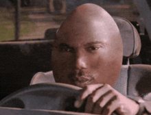 a man in a car with a very large head
