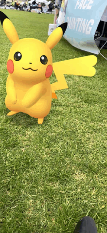 a pikachu is standing in the grass in front of a pace painting sign