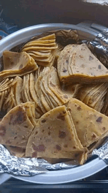 a close up of a pan filled with tortilla chips on foil .