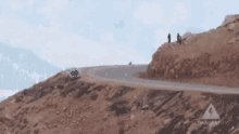 a car is driving down a curvy road on a mountain .