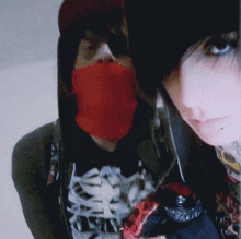 a man and a woman are posing for a picture with the man wearing a red bandana around his face