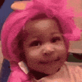 a little girl wearing a pink hat with a bow on it