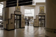 a man walking in a mall with signs for cinemas and shopping