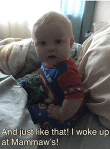 a baby wearing a captain america outfit is sitting on a bed