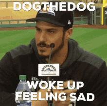 a man wearing a hat is talking into a microphone with the words dog the dog woke up feeling sad below him