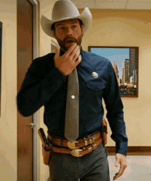 a man wearing a cowboy hat and a blue shirt