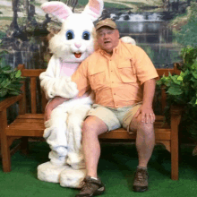 a man sitting on a bench next to a bunny