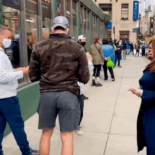 a group of people standing on a sidewalk in front of a building with a sign that says chase bank