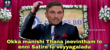 a man speaking into a microphone with the words okka manishi thana jeevintham lo