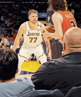 a man in a lakers jersey is kneeling down