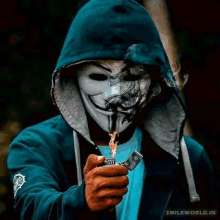 a man wearing a hooded jacket and a mask is holding a lighter .