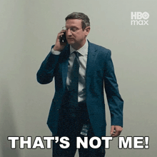 a man in a suit and tie is talking on a cell phone and says that 's not me !