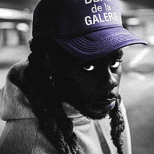 a man wearing a purple hat that says de la galerie on it