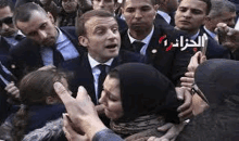 a man in a suit and tie is standing in a crowd of people .