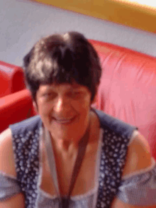 a woman is smiling in front of a red chair