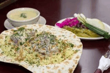 a close up of a plate of food on a table with a bowl of soup .