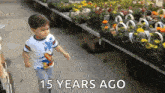 a young boy is running in front of a display of flowers with the words 15 years ago written below him