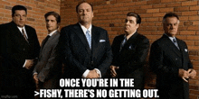 a group of men in suits and ties are standing in front of a brick wall