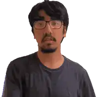 a man wearing glasses and a black shirt is giving the peace sign