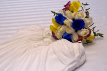 a white dress with a bouquet of blue and yellow roses