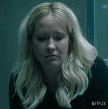 a woman with blonde hair and a necklace is on a netflix ad