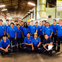 a group of workers posing for a picture in front of a sign that says b on it