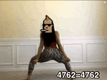 a woman is dancing in a room with a cartoon character on her head .