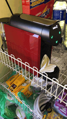 a red delta q coffee maker sits next to a box of nestle energy drink