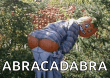 a scarecrow with a pumpkin on his head has the word abracadabra written on the bottom