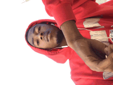 a man wearing a red hoodie that says ' nm ' on it