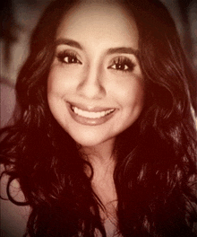 a black and white photo of a smiling woman with long dark hair