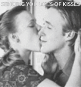a black and white photo of a man and a woman kissing with the caption sending you lot 's of kisses