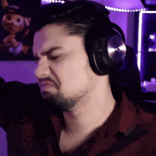 a man with a beard wearing headphones making a funny face