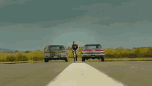 a man in a military uniform stands between two classic cars one of which has a california license plate that says party111